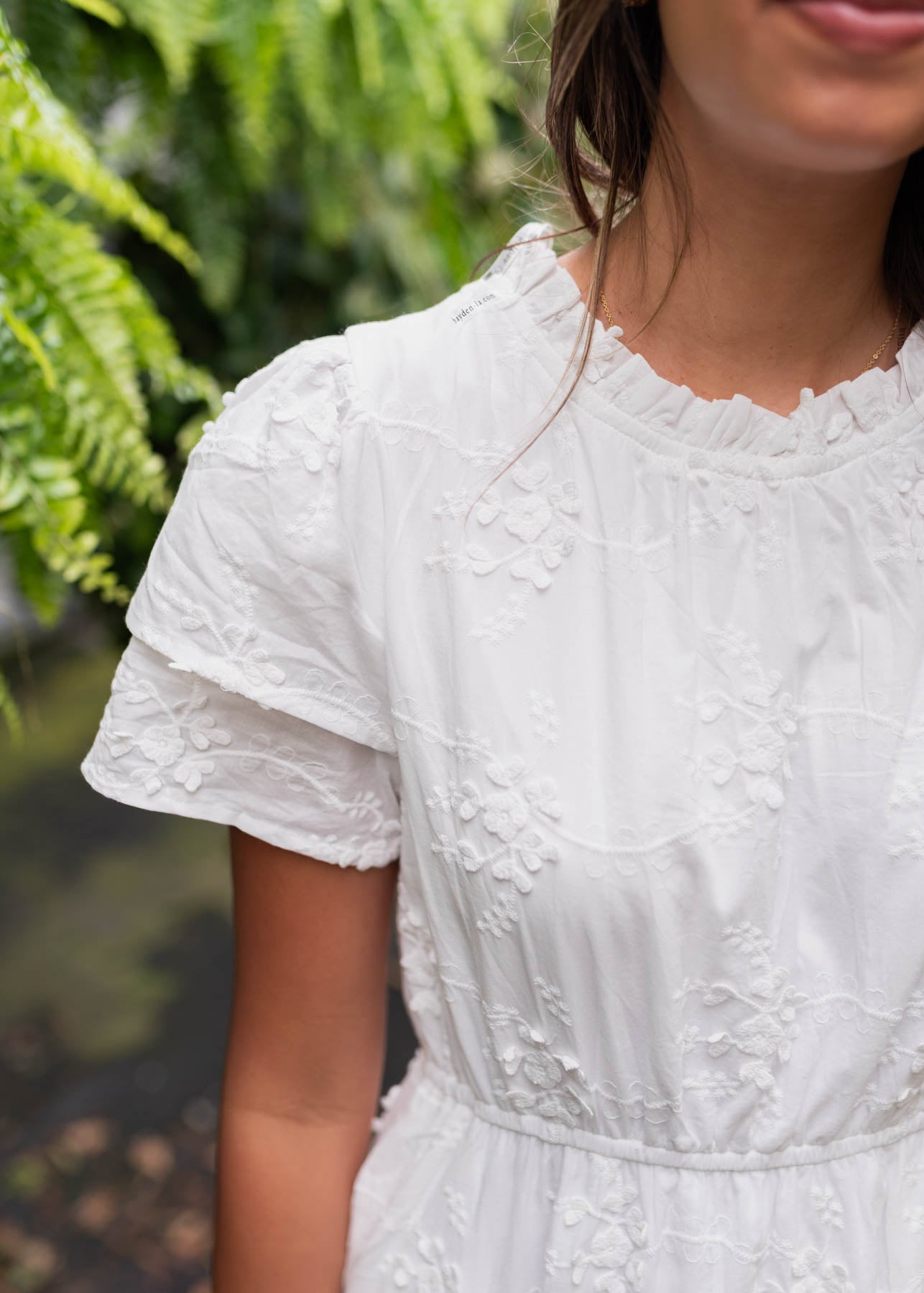 White floral embroidered dress with ruffle at the neck and double cuff