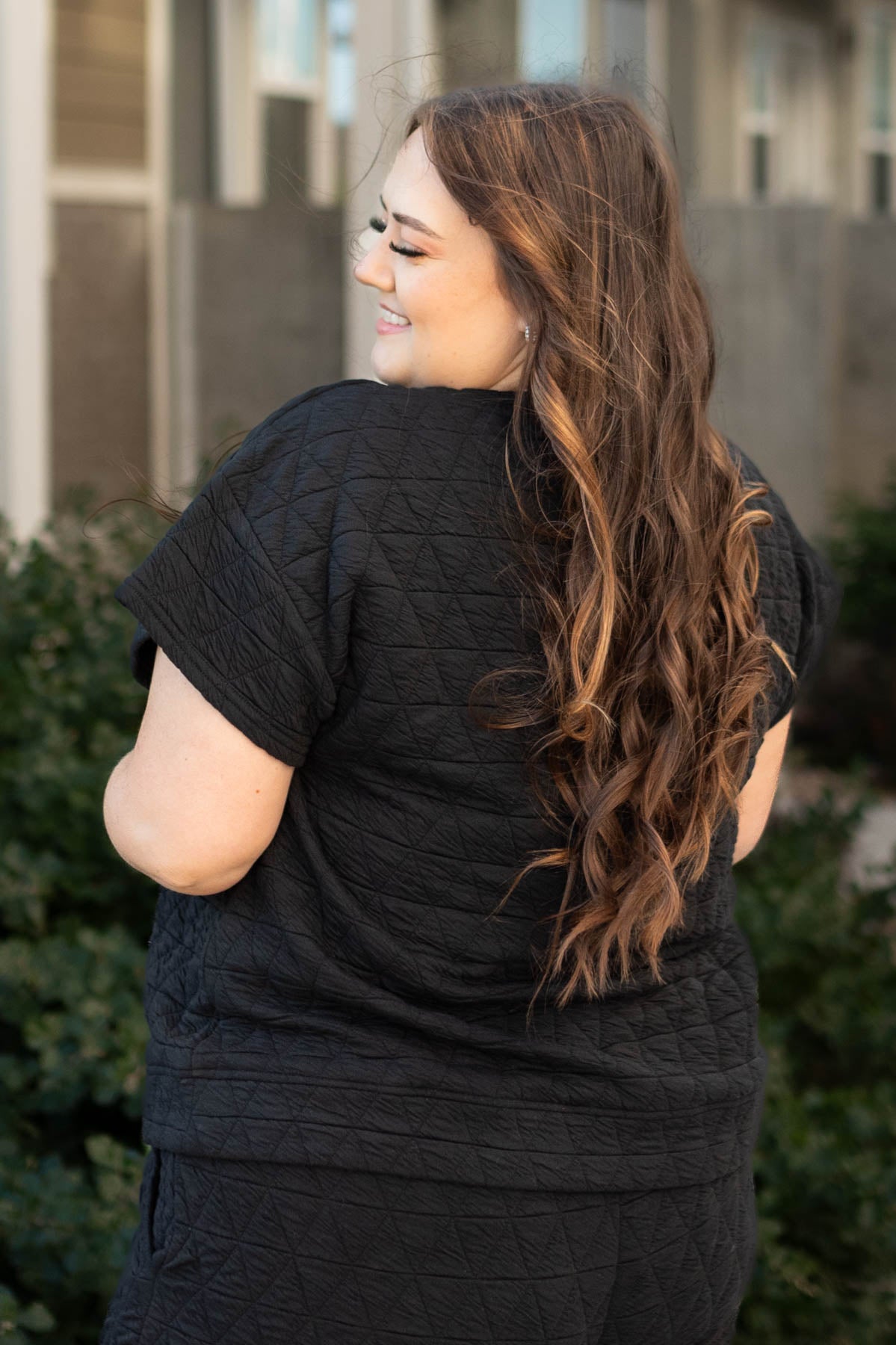 Back view of a plus size quilted black top