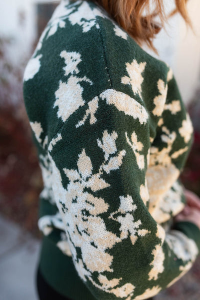 Close up of the floral pattern on a green floral sweater