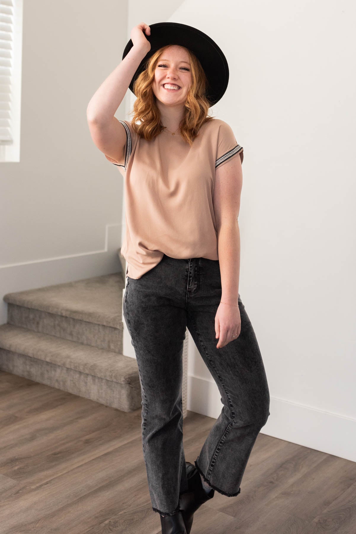 Black trim on the cuffs of a taupe top
