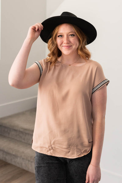 Short sleeve taupe top with black trim on the cuffs