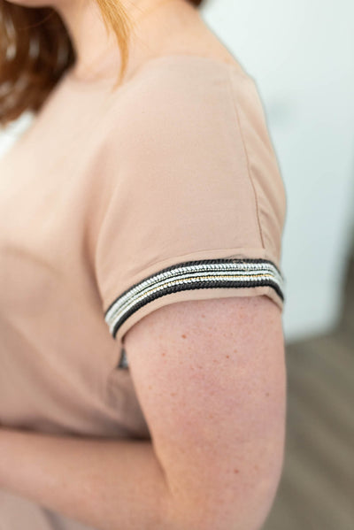 Close up view of the sleeve of the taupe top