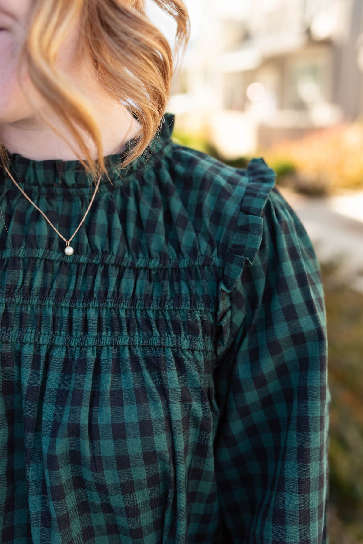 Close up of the smocking on the hunter green ruffle blouse