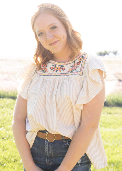 Taupe top with embroidery at the neck and ruffle sleeves