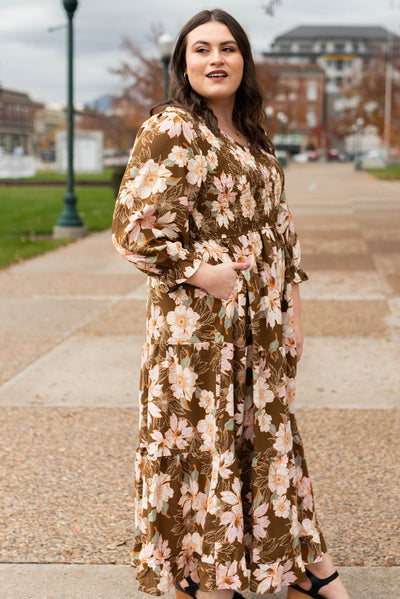 Side view of a plus size brown floral dress with pockets