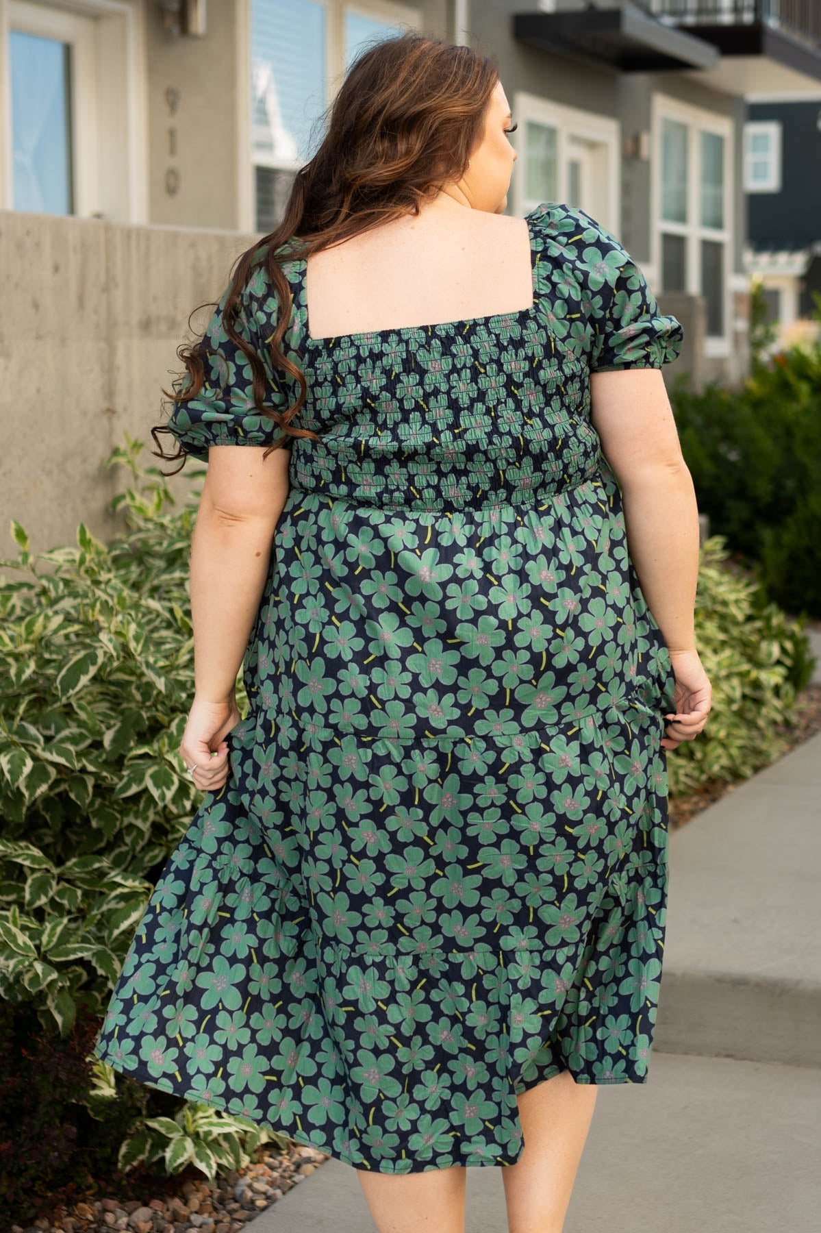 Back view of a plus size dark green dress