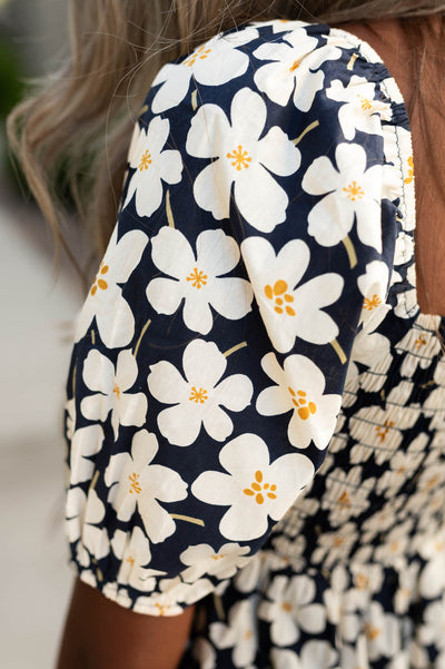 Sleeve of a floral print ivory dress