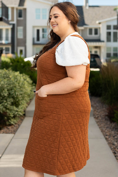 Side view of a plus size cinnamon dress with pockets