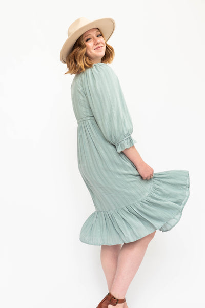 Side view of a vintage seafoam green dress with 3/4 sleeve.
