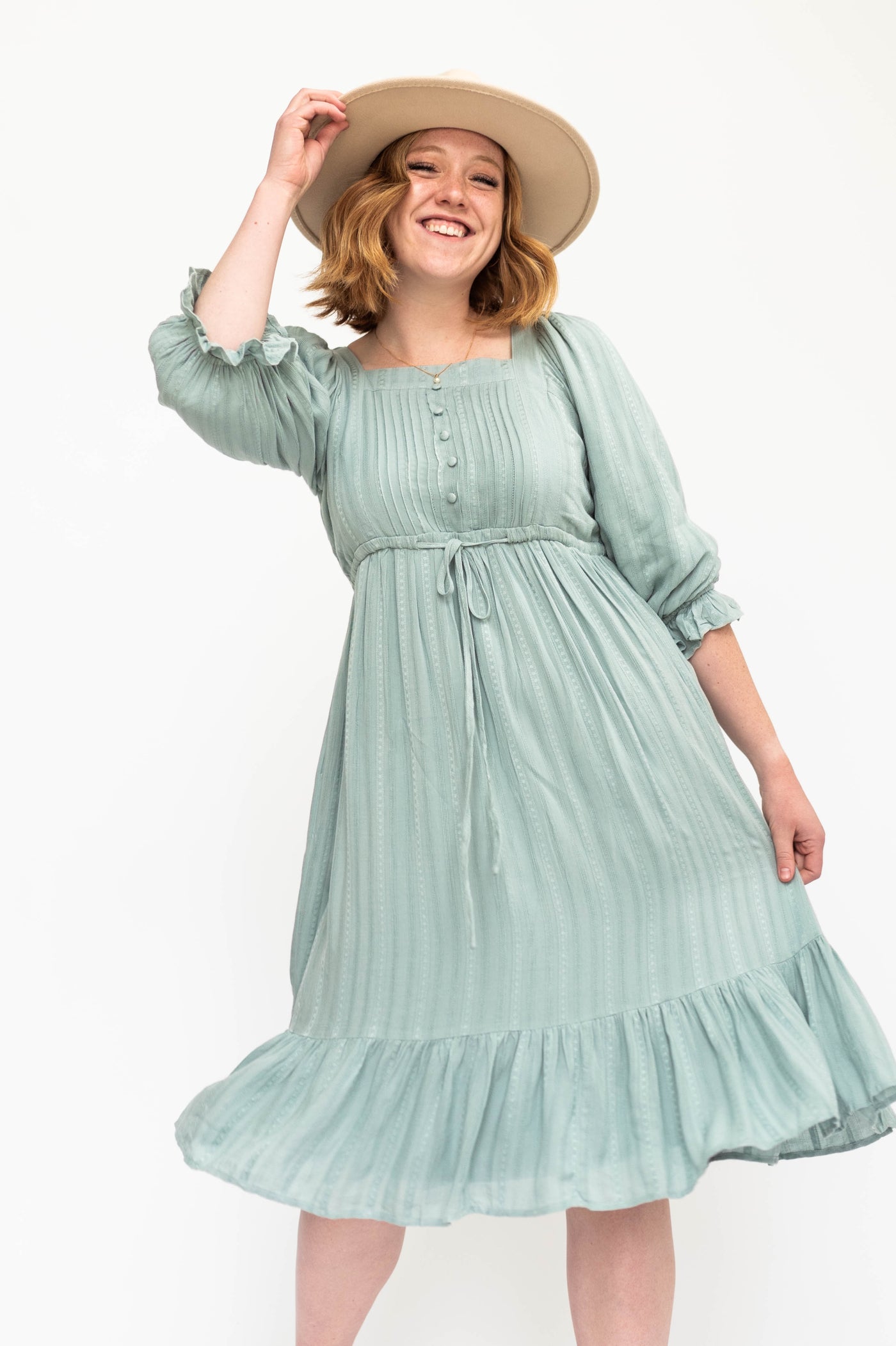 Seafoam green dress with 3/4 sleeves and a pleated bodice.