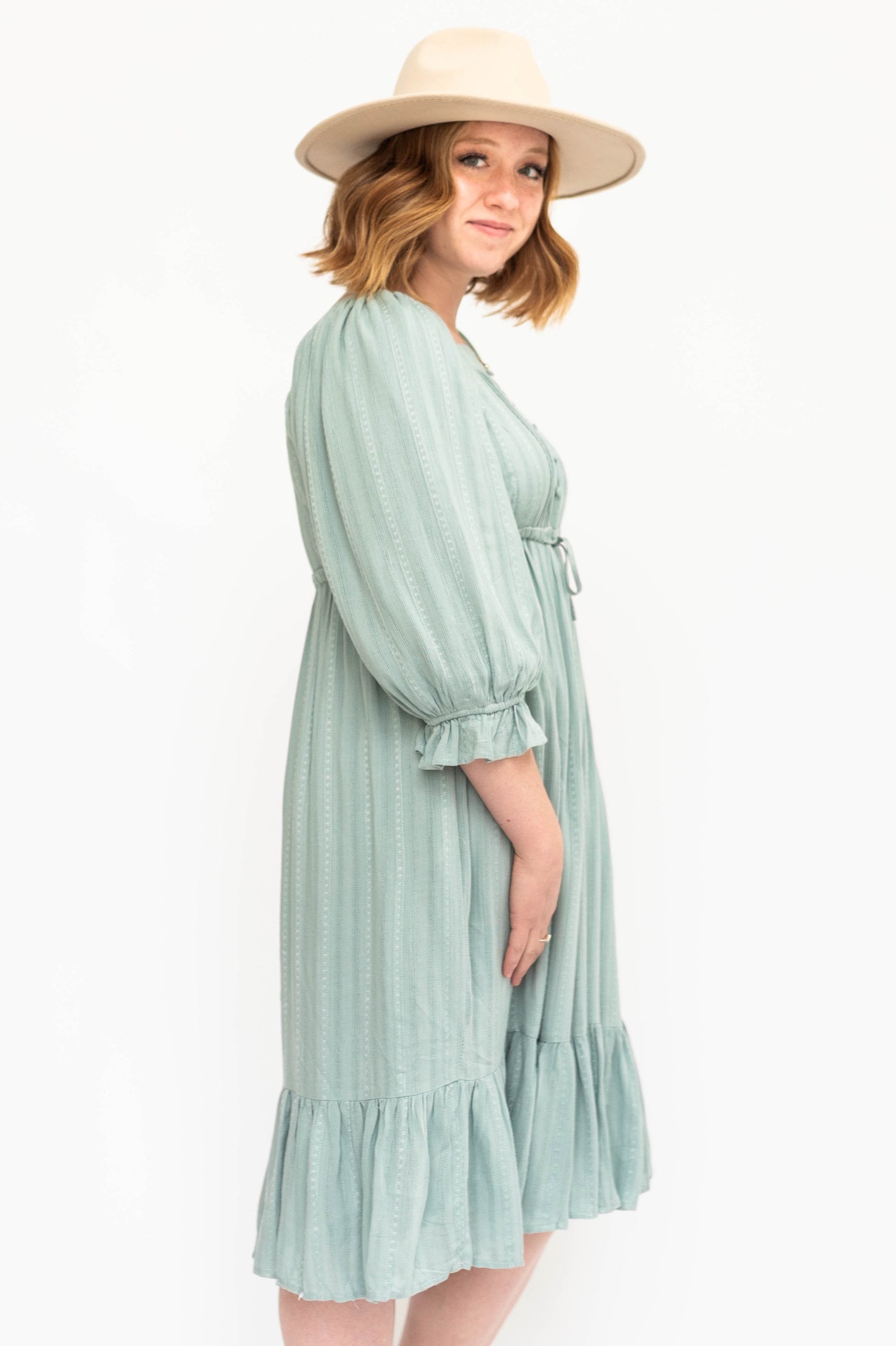 Side view of a vintage seafoam green dress that ties at  the waist.