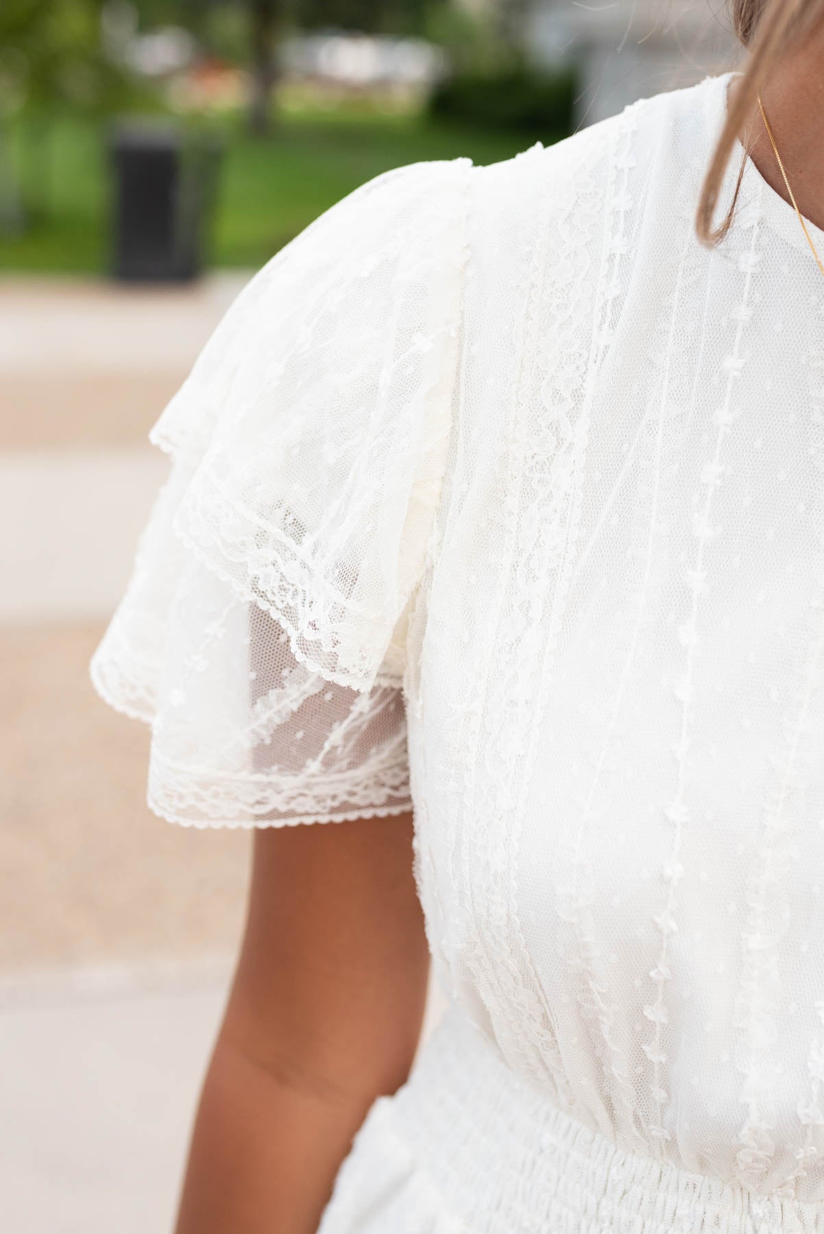 Close up of the lace and sleeve on the cream lace dress