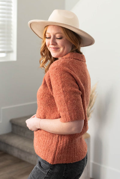 Side view of a terracotta knit sweater