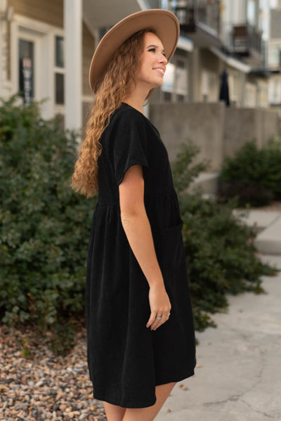 Side view of a black corduroy button up dress