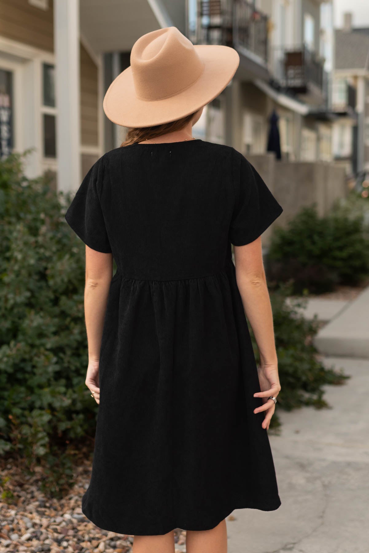 Back view of a black corduroy button up dress