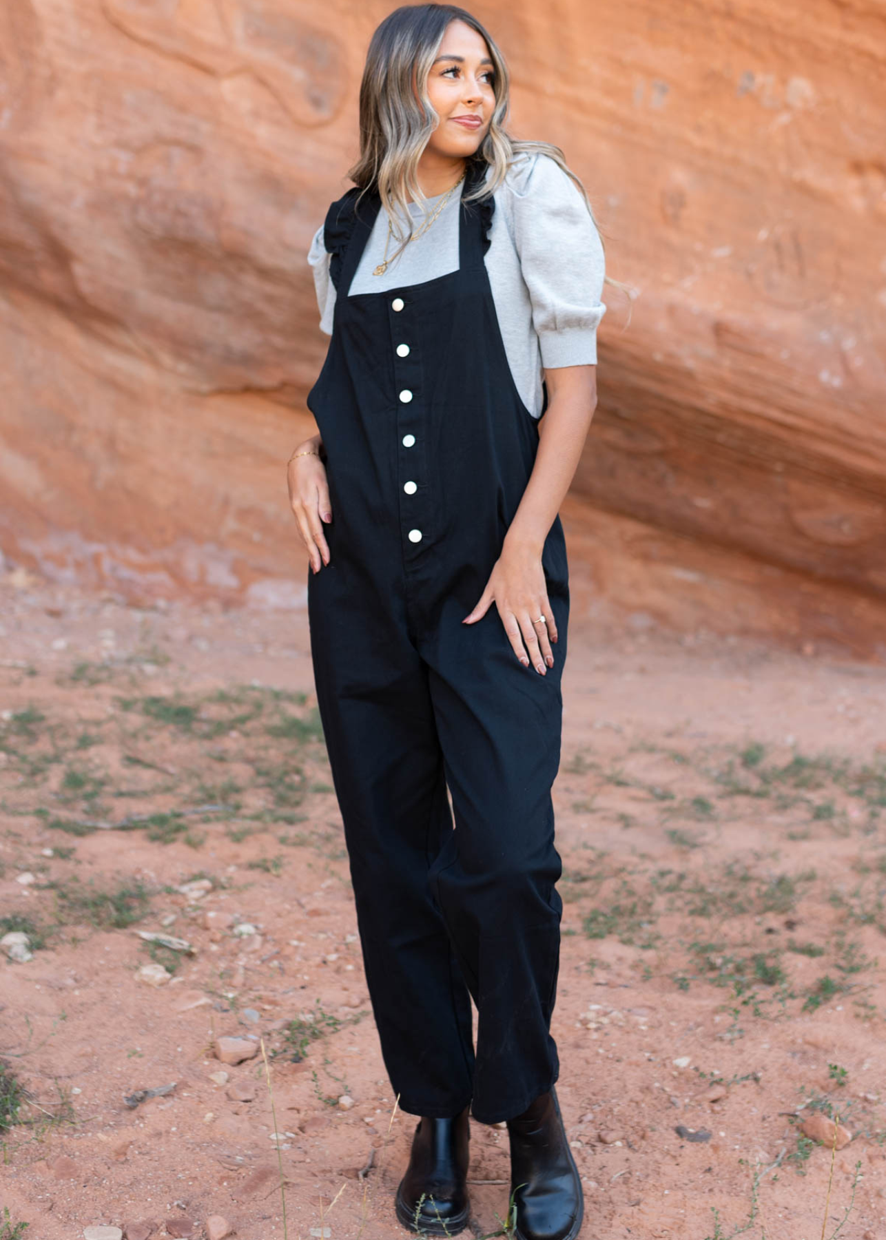 Black jumpsuit with white buttons and ruffle straps