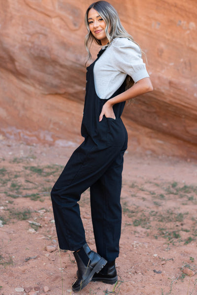 Side view of a black jumpsuit with back pockets
