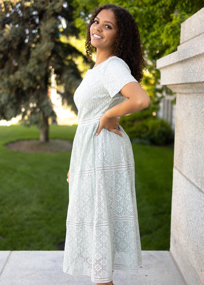 Side view of a dusty sage lace dress with short sleeves 