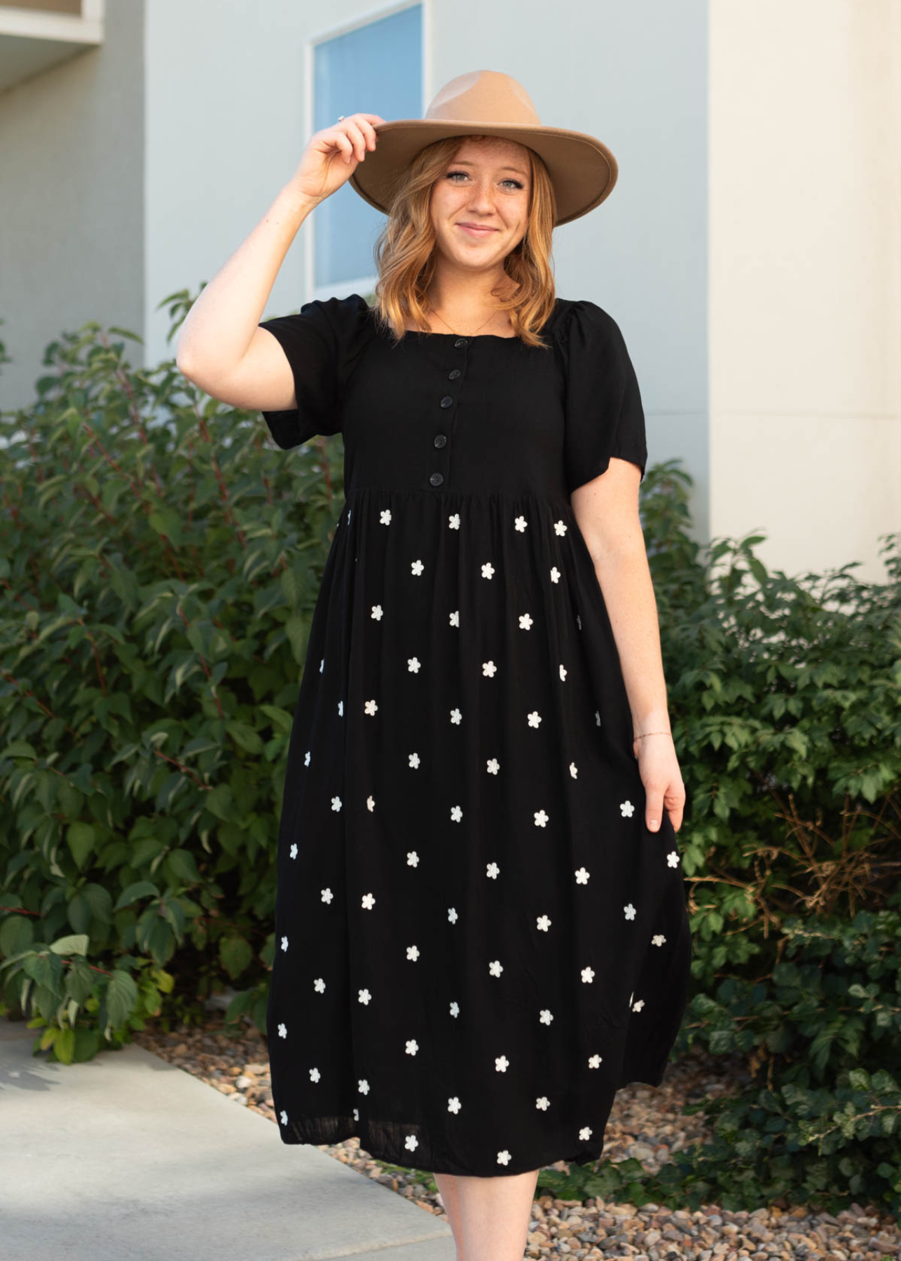 Short sleeve black dress with buttons on the bodice and small white flowers on the skirt