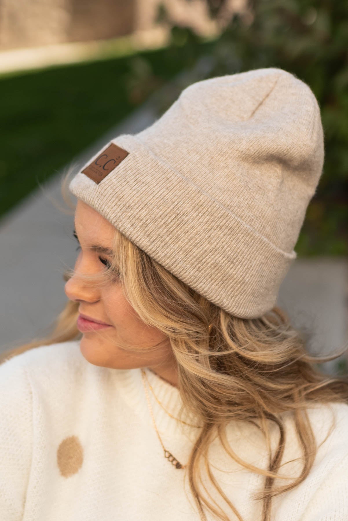 Beige knit beanie with a brown patch