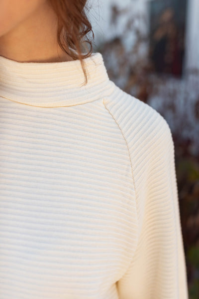 Close up view of the cream textured sweater