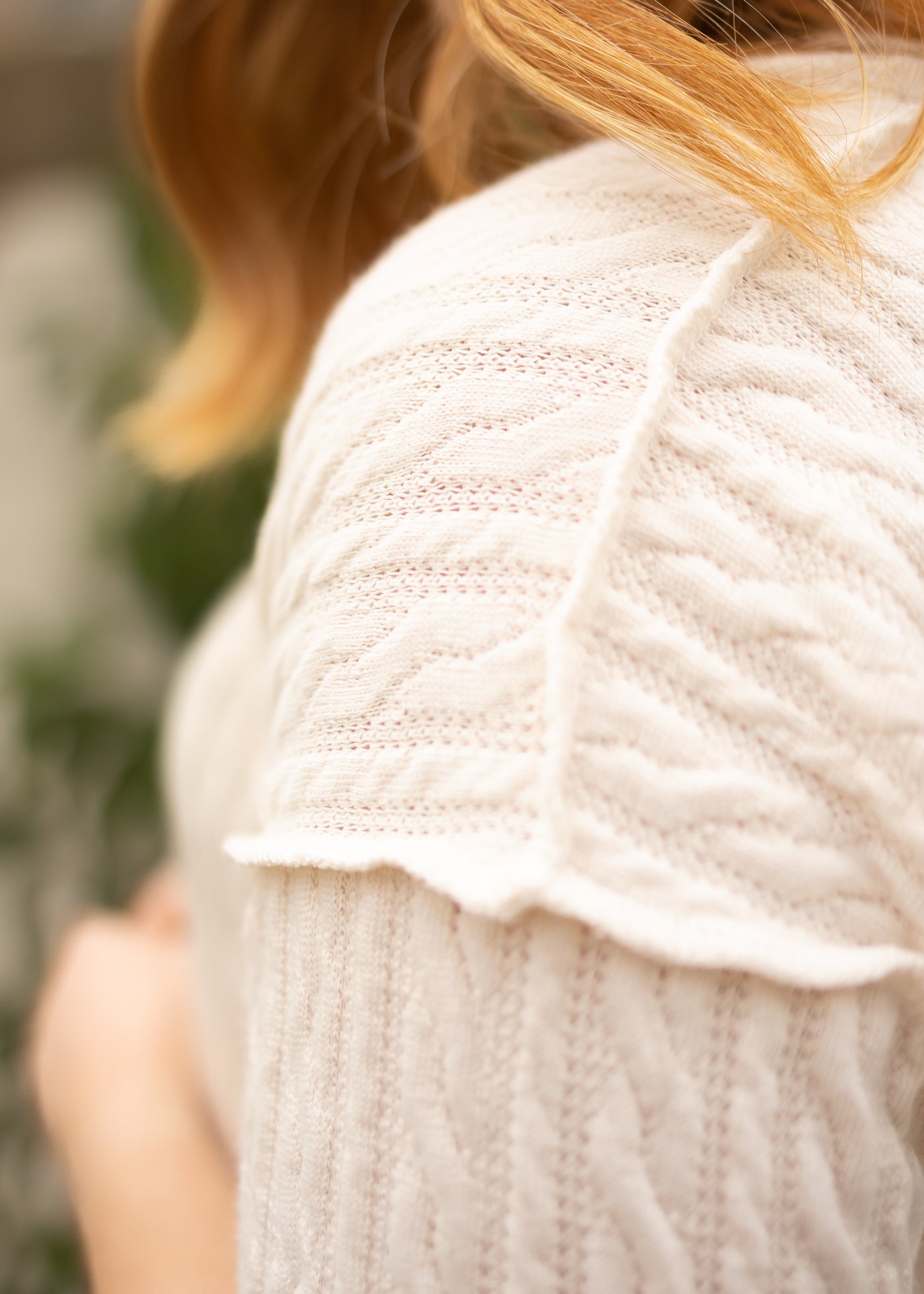 Shoulder view of a short sleeve cream top