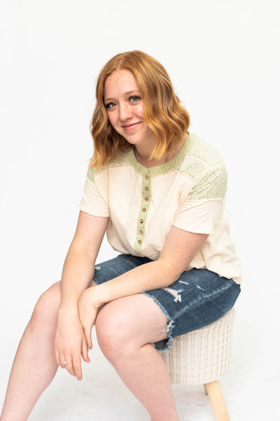Short sleeve cream knit top with button detail green tea mini flower fabric at the shoulders. 