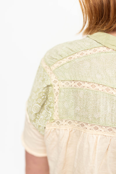 Back view of a short sleeve green tea top with lace