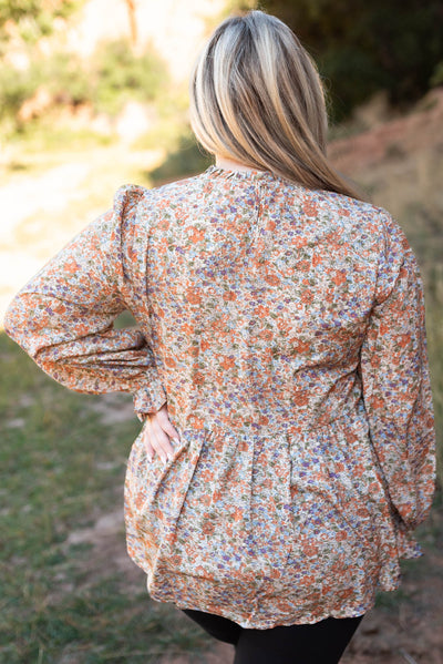 Back view of a plus size rust floral top
