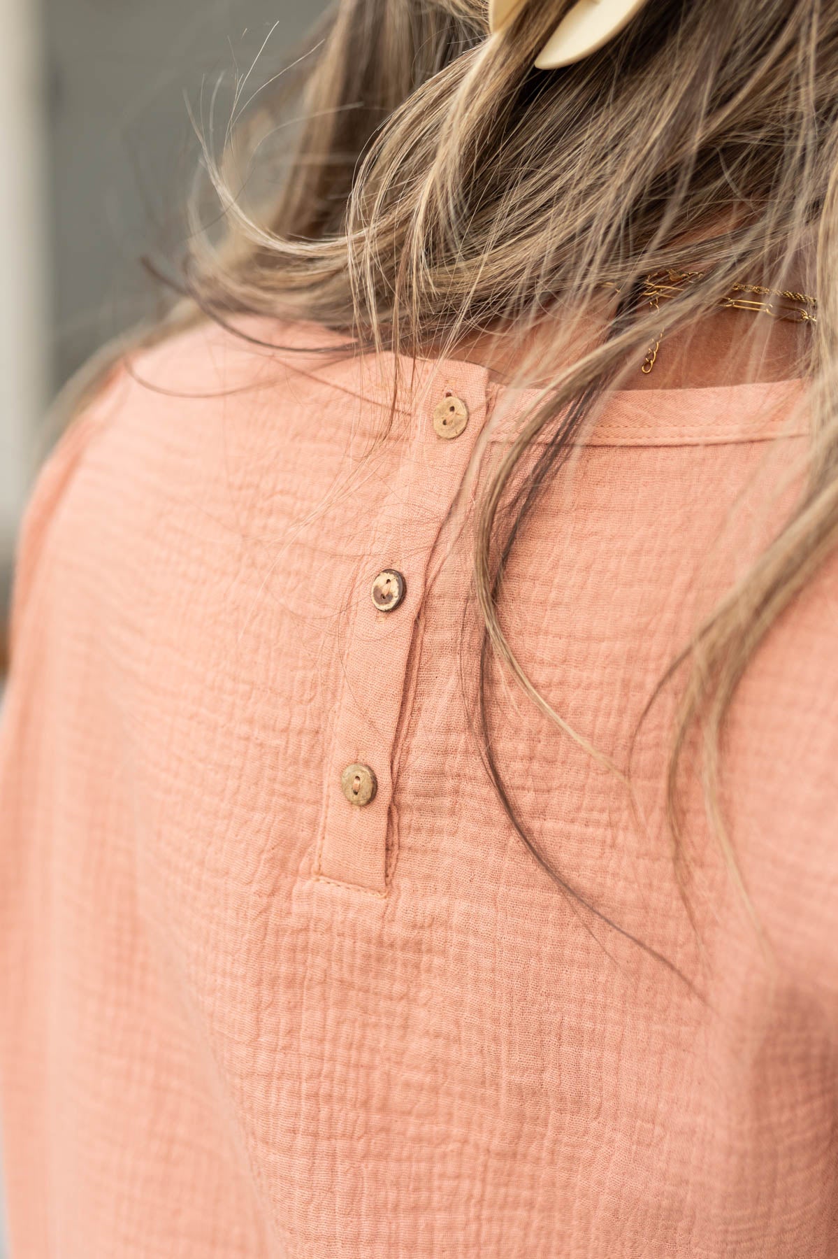 Buttons on the back of a dusty coral top