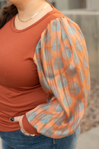 Sheer pattern sleeve on a rust top