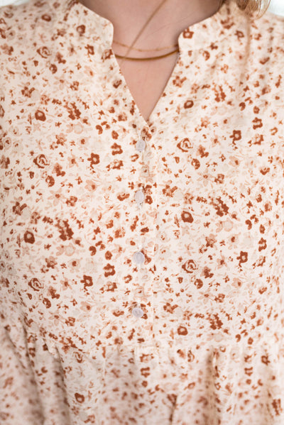 Close up of the fabric and buttons on the bodice of the beige floral dress