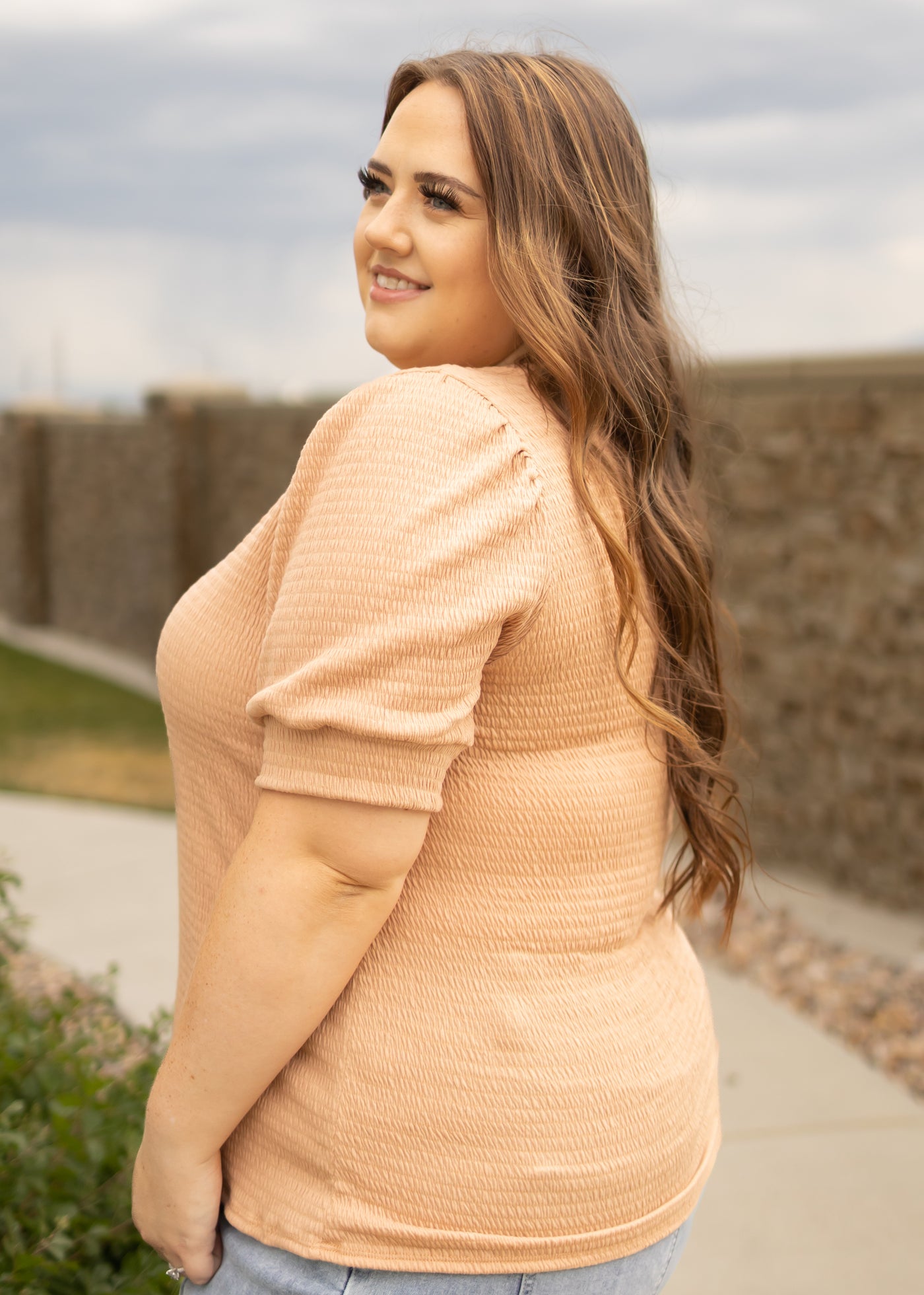 Side view of a plus size almond top with short sleeves