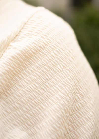 Textured fabric of a plus size cream top