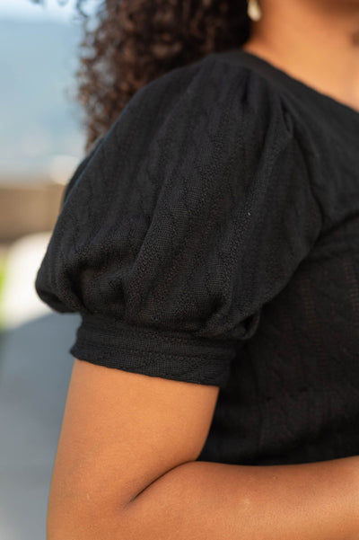 Sleeve view of a short sleeve black top