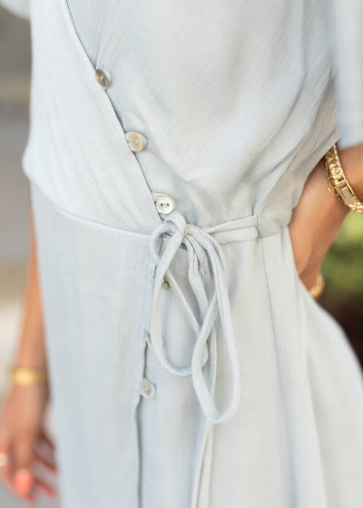 Close up of the side and buttons on the dusty blue wrap dress