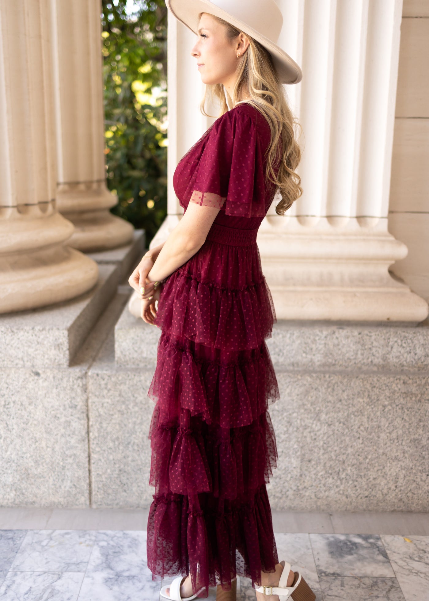 Side view of a short sleeve burgundy dress with a ruffle skirt