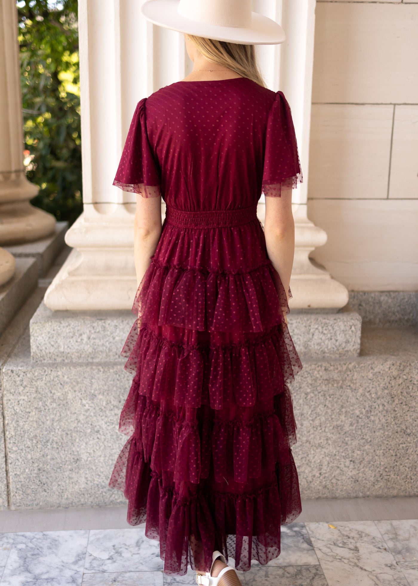 Back view of a burgundy dress with a ruffle skirt
