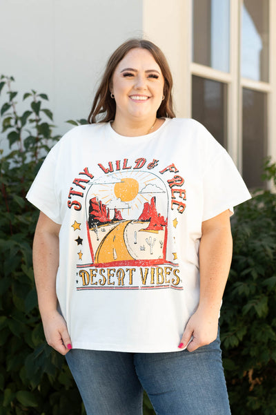 Front view of a plus size stay wild and free ivory tee