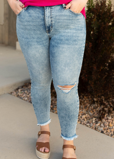 Plus size medium wash jeans with frayed hem