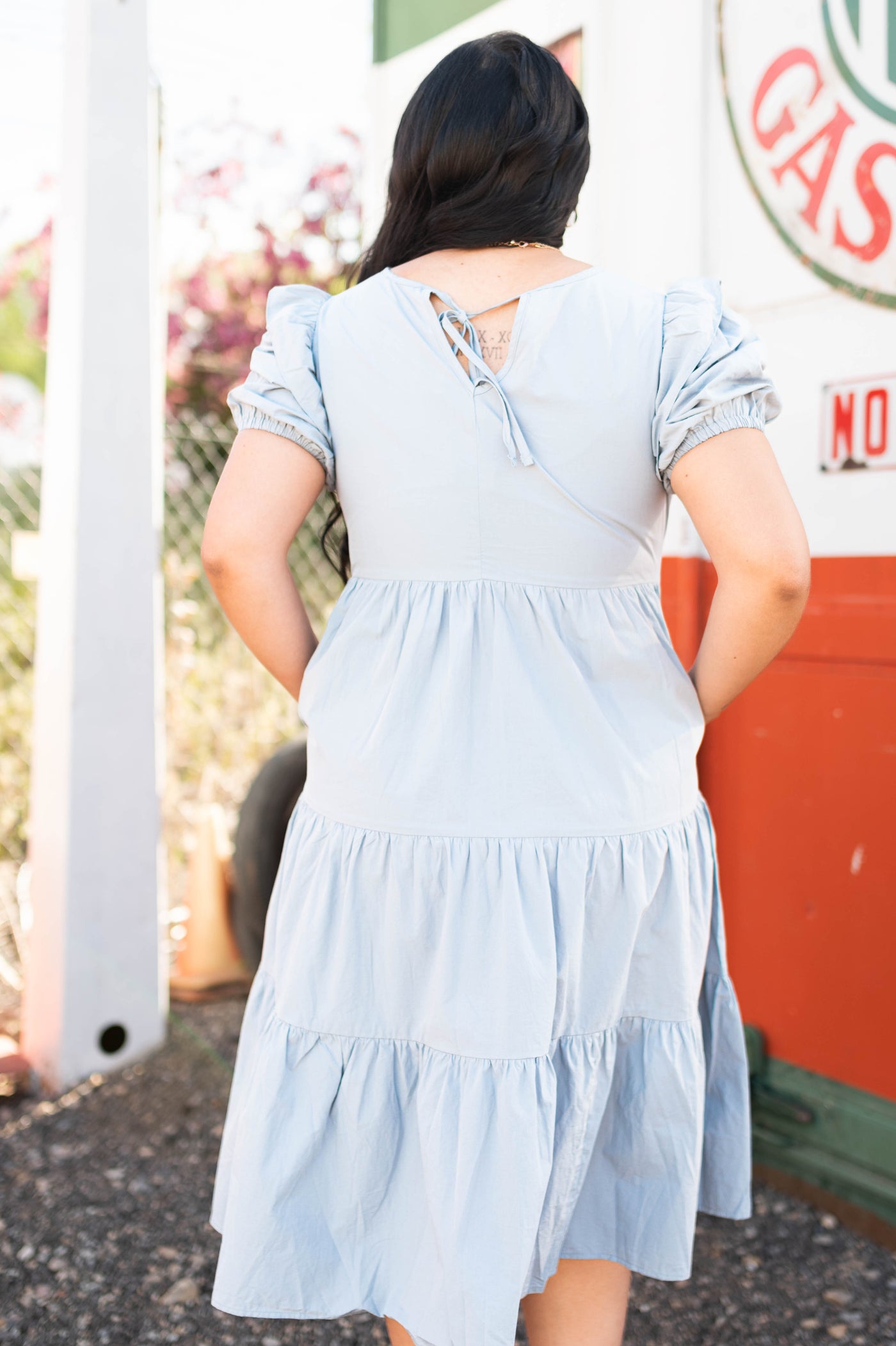 Back view of a stone blue dress with tiered skirt