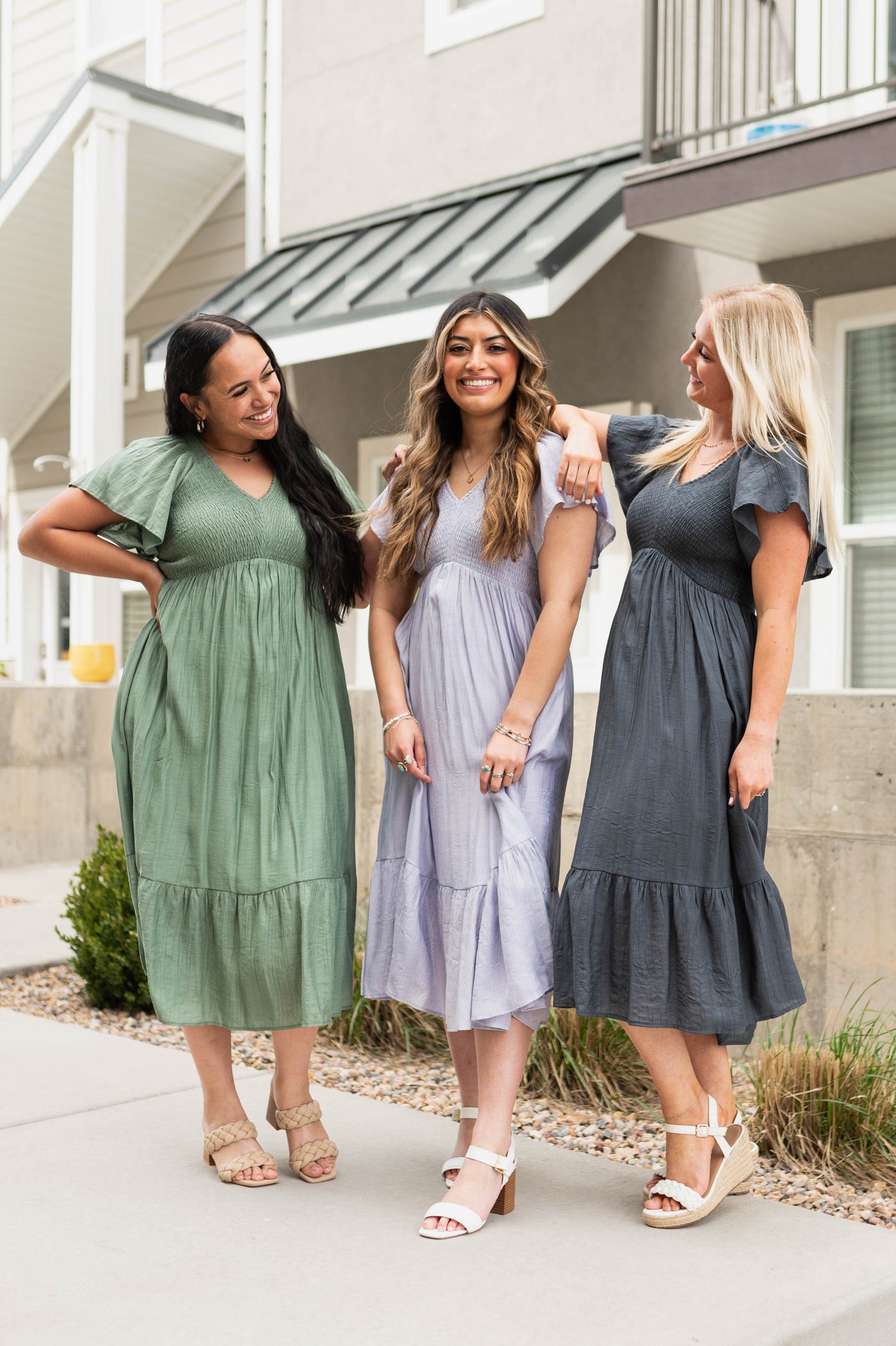 Dusty sage, lavender and denim blue satin calf length dresses, high waisted, short sleeve and smocked bodice.