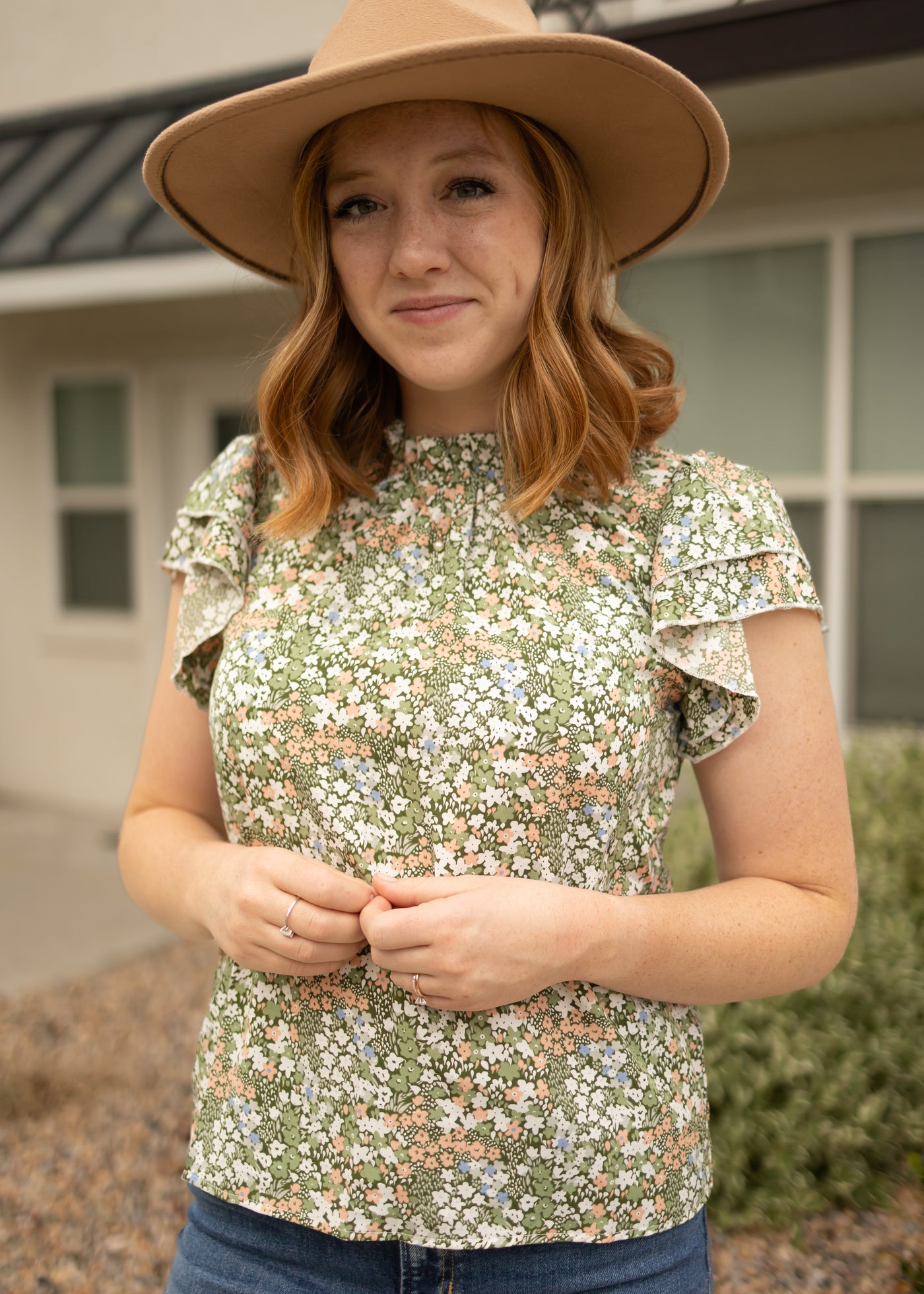 Front view of a green floral top with ruffle sleeves