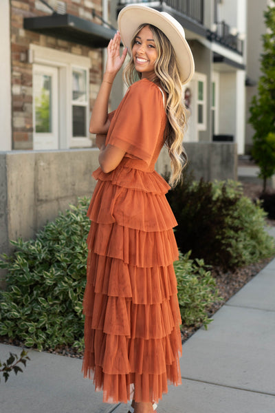 Side view of rust dress with ruffle skirt