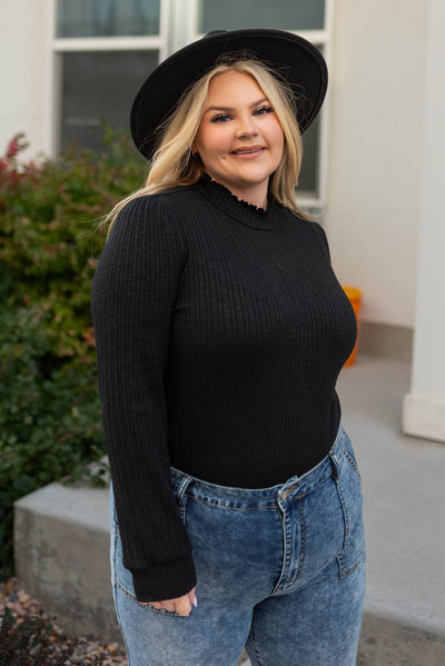 Mock turtleneck on a plus size black top with long sleeves