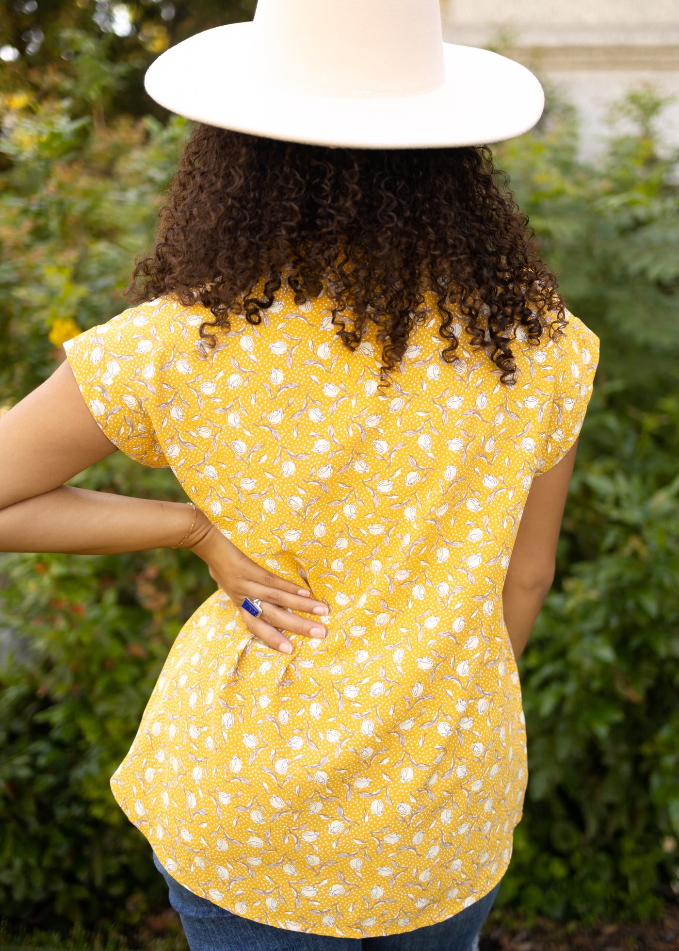 Back view of a marigold floral top