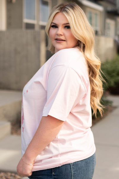 Side view of a plus size the world needs pink tee