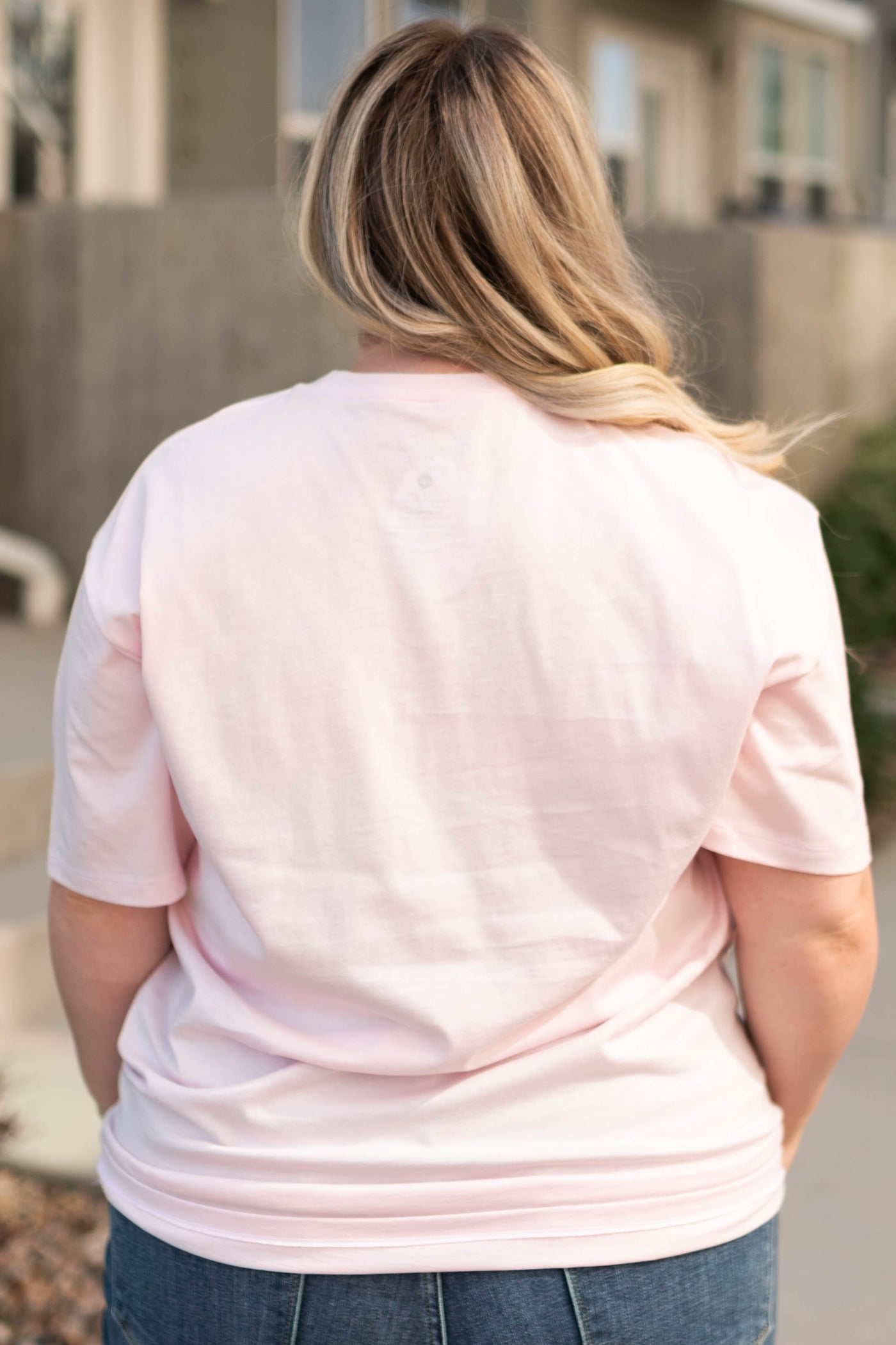 Back view of a plus size the world needs pink tee