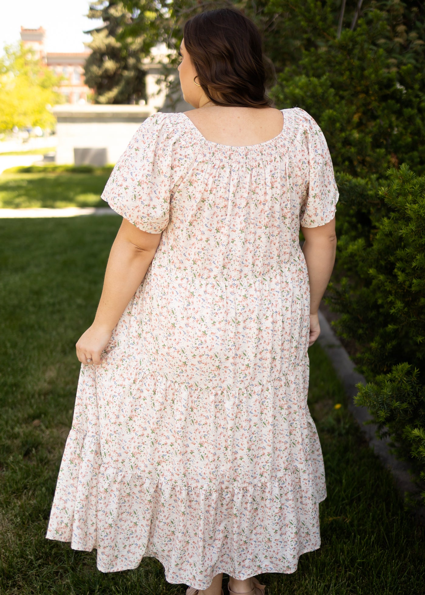 Back view of a cream floral dress with a tiered skirt