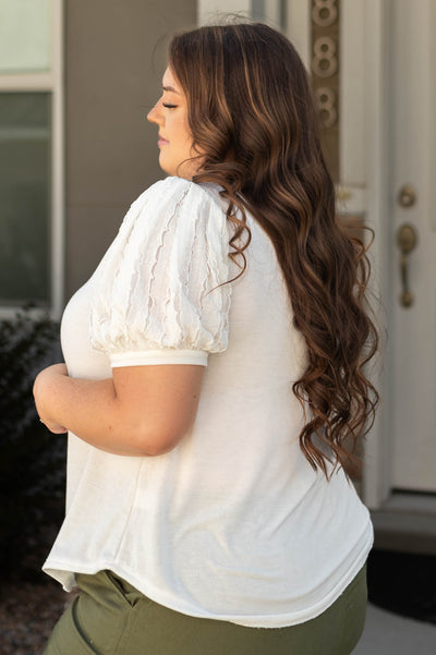 Sleeve detail of a plus size short sleeve white top